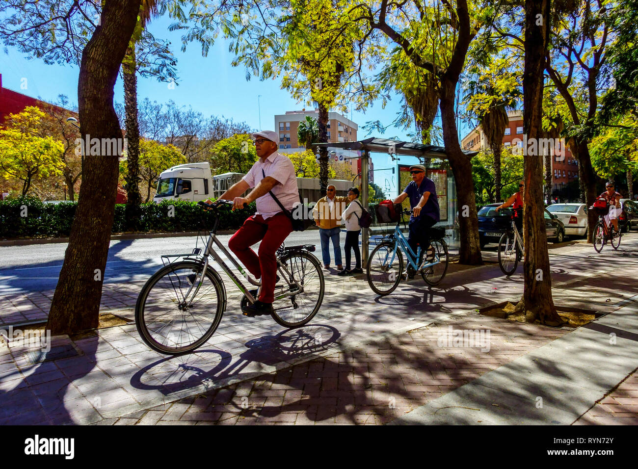 Valencia gente in bicicletta, la strada sotto gli alberi, Valencia primavera Spagna città bicicletta Valencia Spagna Europa Foto Stock