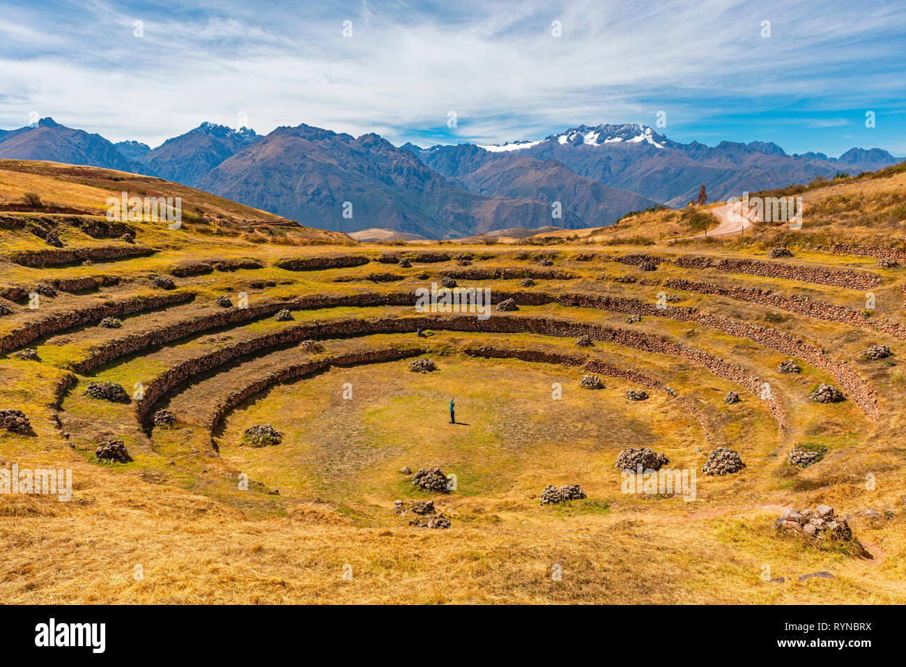 Una donna di eseguire esercizi yoga nel sito Inca di Moray, famoso per la sua forma circolare campi terrazzati, utilizzato per l'agricoltura la scienza, Cusco, Perù. Foto Stock