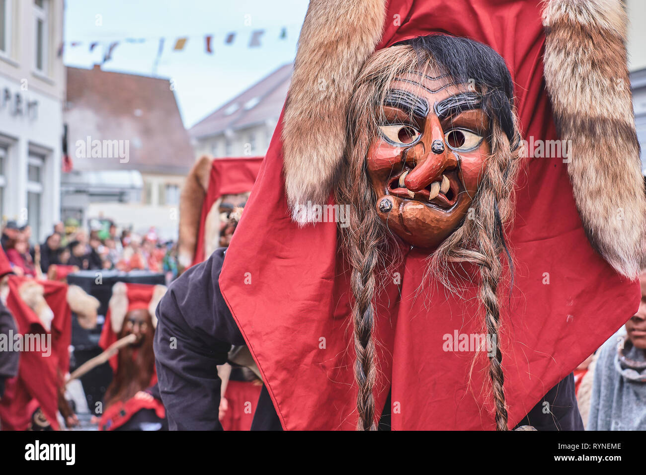 Shrovetide figura con cappuccio rosso e pigtail. Strada di Carnevale nel sud della Germania - Foresta Nera. Foto Stock