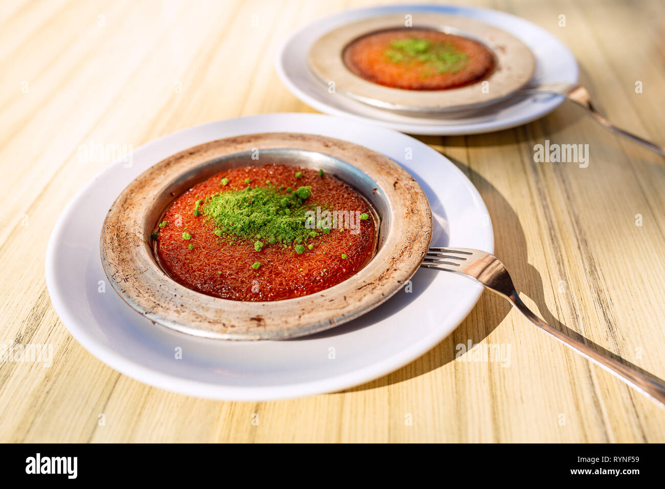 Dolce turco kunefe, kunafa, kadayif con polvere di pistacchi e formaggio servito caldo, molto dolce. Bagno turco dessert tradizionale Foto Stock