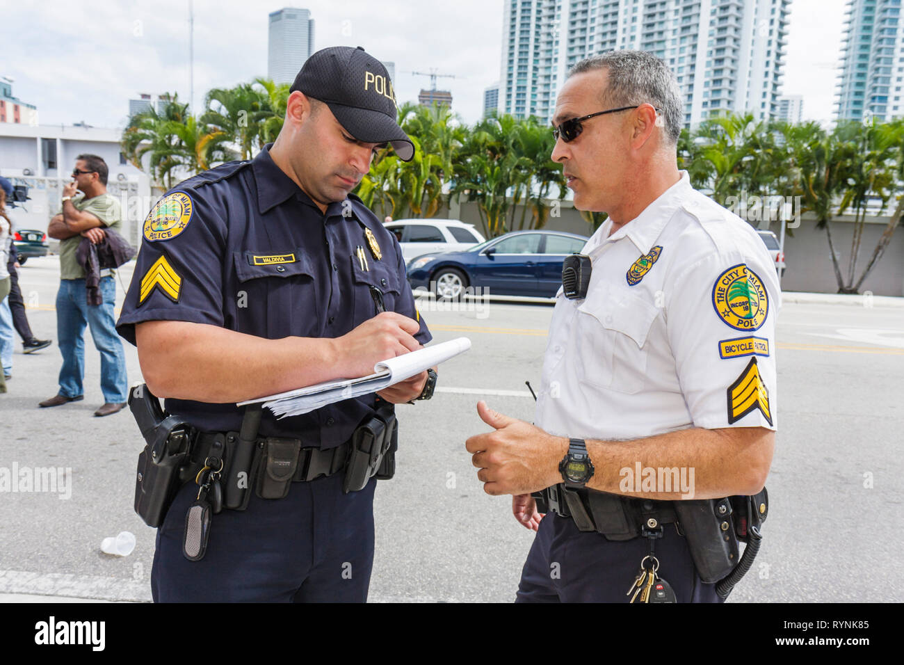 Miami Florida,uomo ispanico uomini maschio,polizia,poliziotto,ufficiale,uniforme,lavoro,lavoro,dipendenti lavoratori dipendenti personale,pubblica sicurezza,proteggere,sicurezza,parlare Foto Stock