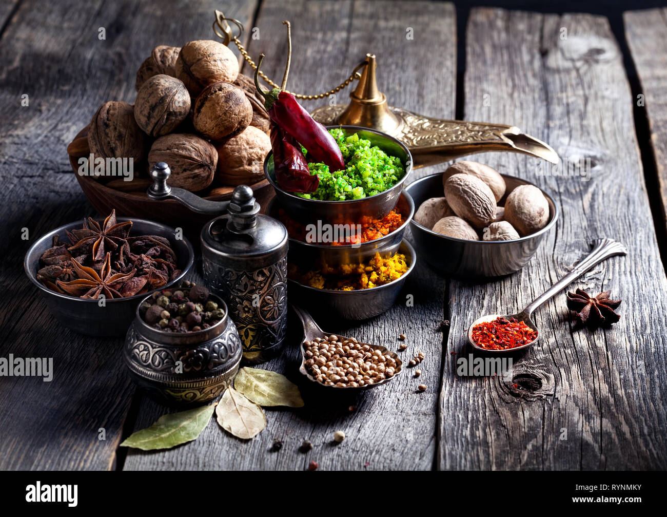Spezie, pepe macinino, cucchiaio con semi a grigio Sfondo di legno Foto Stock
