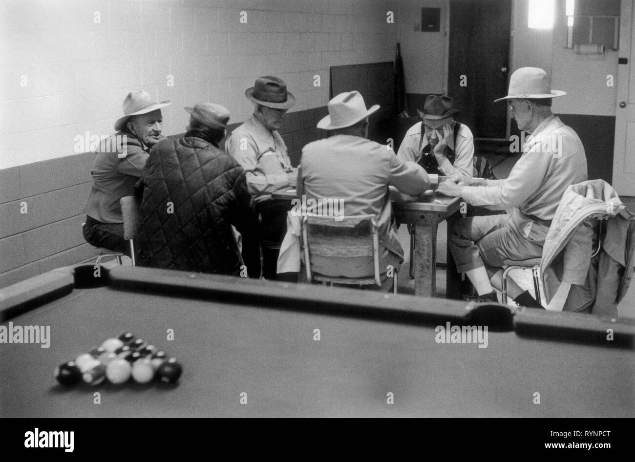 Sala da biliardo degli anni '1970 USA. Gruppo di anziani che giocano a domino parlando passando l'ora della giornata concentrandosi indossando cappelli da cowboy e una scena interna di reportage. Astec New Mexico US 70S HOMER SYKES Foto Stock
