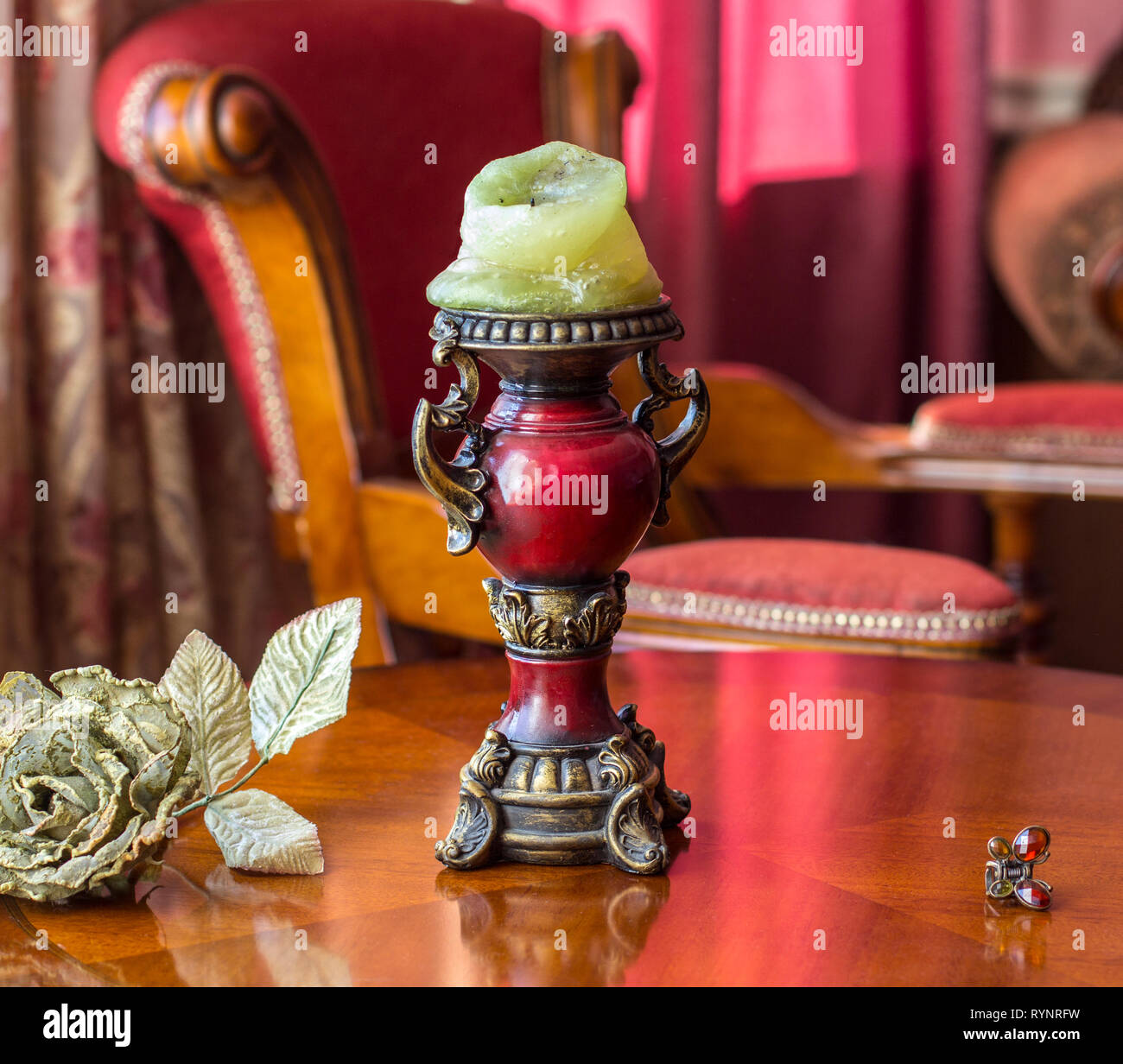 Vintage candelabro sul tavolo accanto a un'artificiale rosa e una forcina nell idea di una farfalla Foto Stock