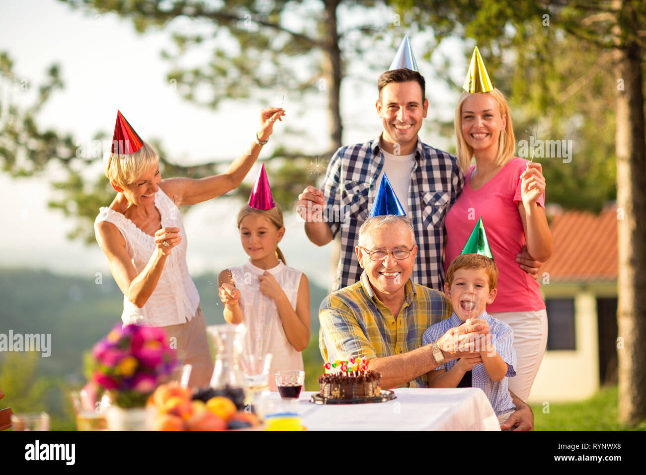 Ritratto di una famiglia felice in parte i cappelli e gli sprinkler Foto Stock