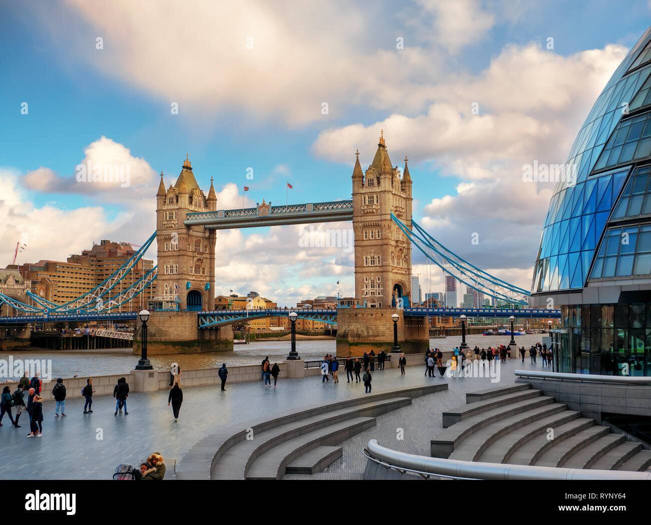 Londra, Inghilterra - Marzo 10, 2019: la splendida vista del Tower Bridge da più Luogo di Londra con i turisti a piedi lungo il fiume al tramonto Foto Stock