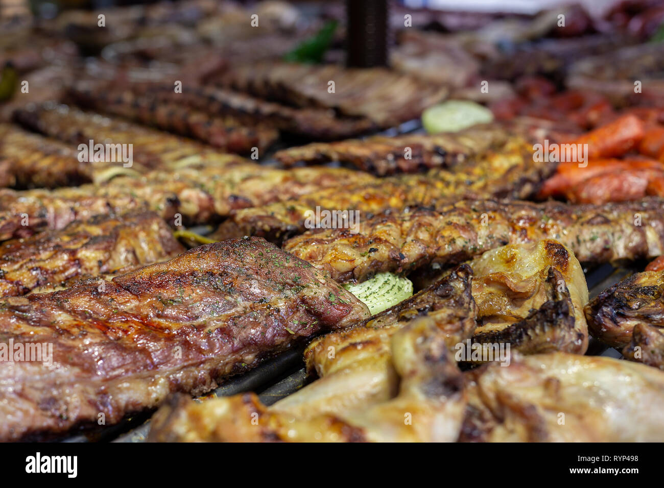 Costolette di maiale e salsicce alla griglia in un barbecue Foto Stock