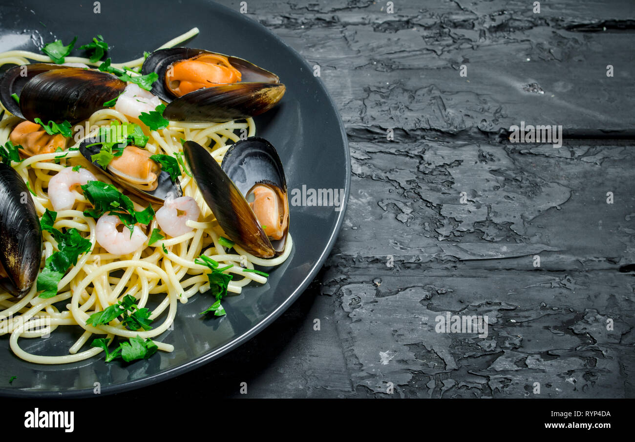 Cucina mediterranea. Spaghetti con le vongole. Nero a sfondo rustico. Foto Stock