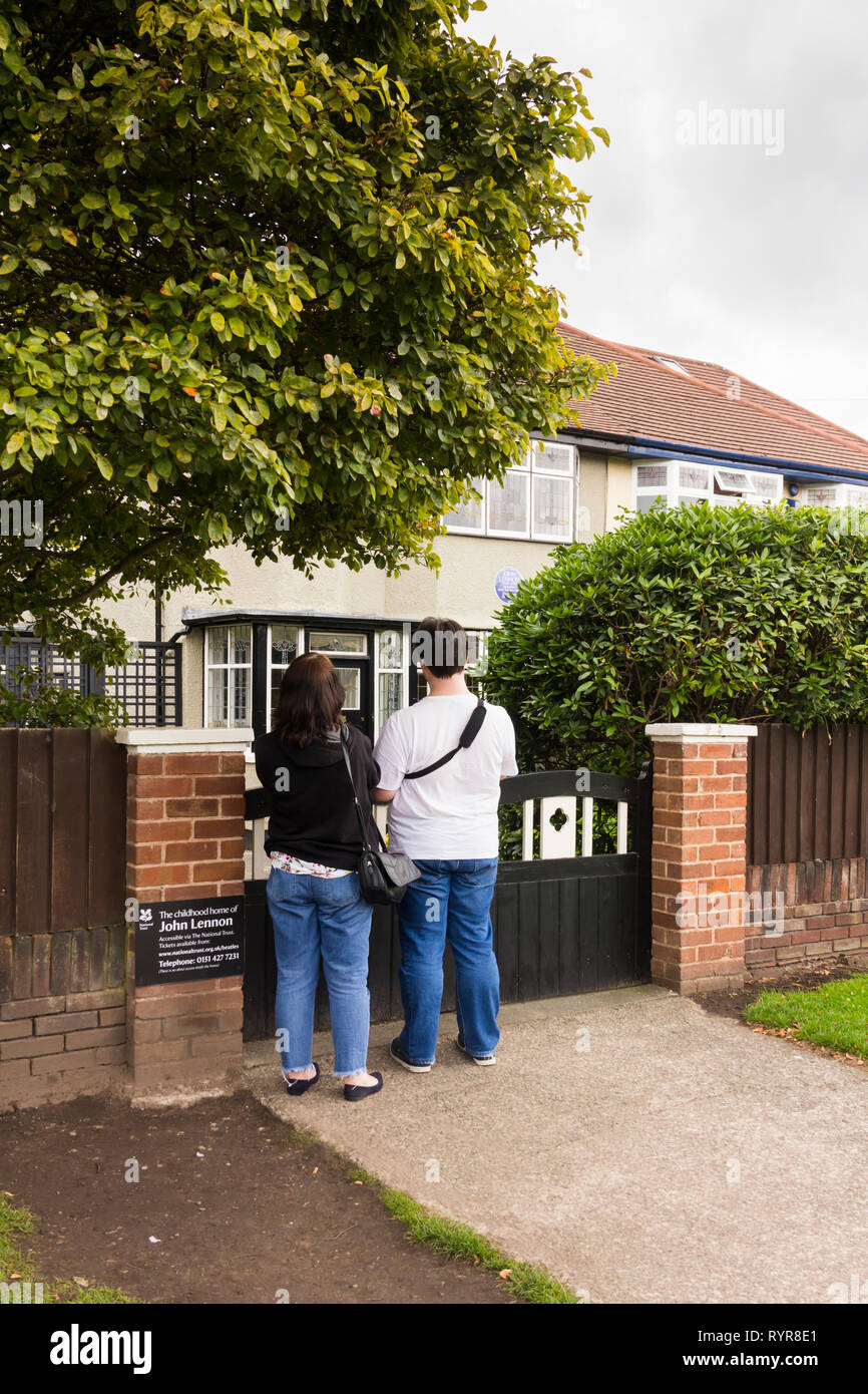 Due visitatori permanente al cancello per l'infanzia a casa di John Lennon, Menlove Avenue, Woolton, Liverpool. Il museo alla ex cantante/cantautore Foto Stock