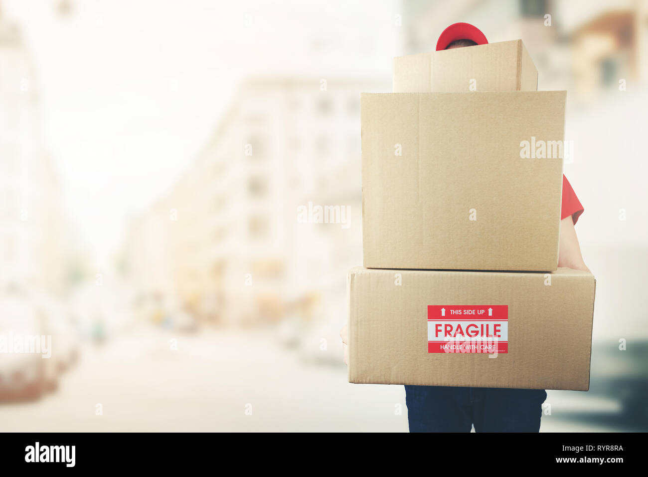 Uomo di consegna con la pila di scatole in piedi sulla strada. spazio copia Foto Stock