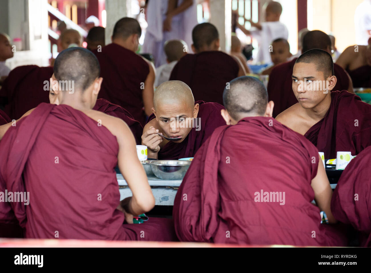 I monaci buddisti coda per il loro pranzo al Monastero Mahagandhayon situato in Amarapura, Myanmar Foto Stock