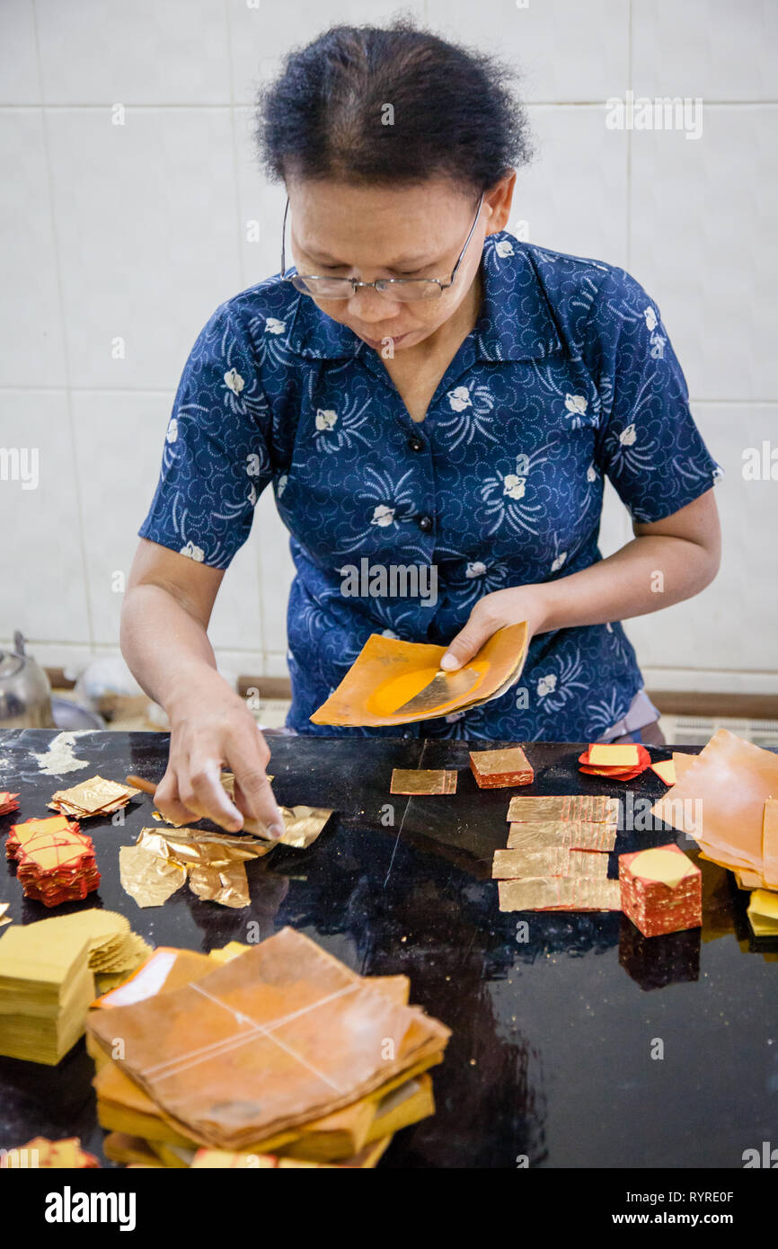 I lavoratori creano la foglia di oro al Re Galon foglia oro workshop a Mandalay, Myanmar Foto Stock