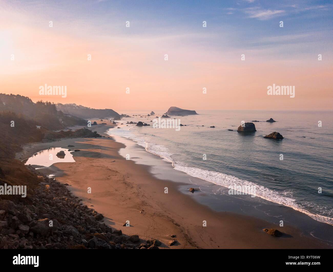 Sunrise, spiaggia sabbiosa, il paesaggio costiero con molte rocce frastagliate isole, Oregon, Stati Uniti d'America Foto Stock