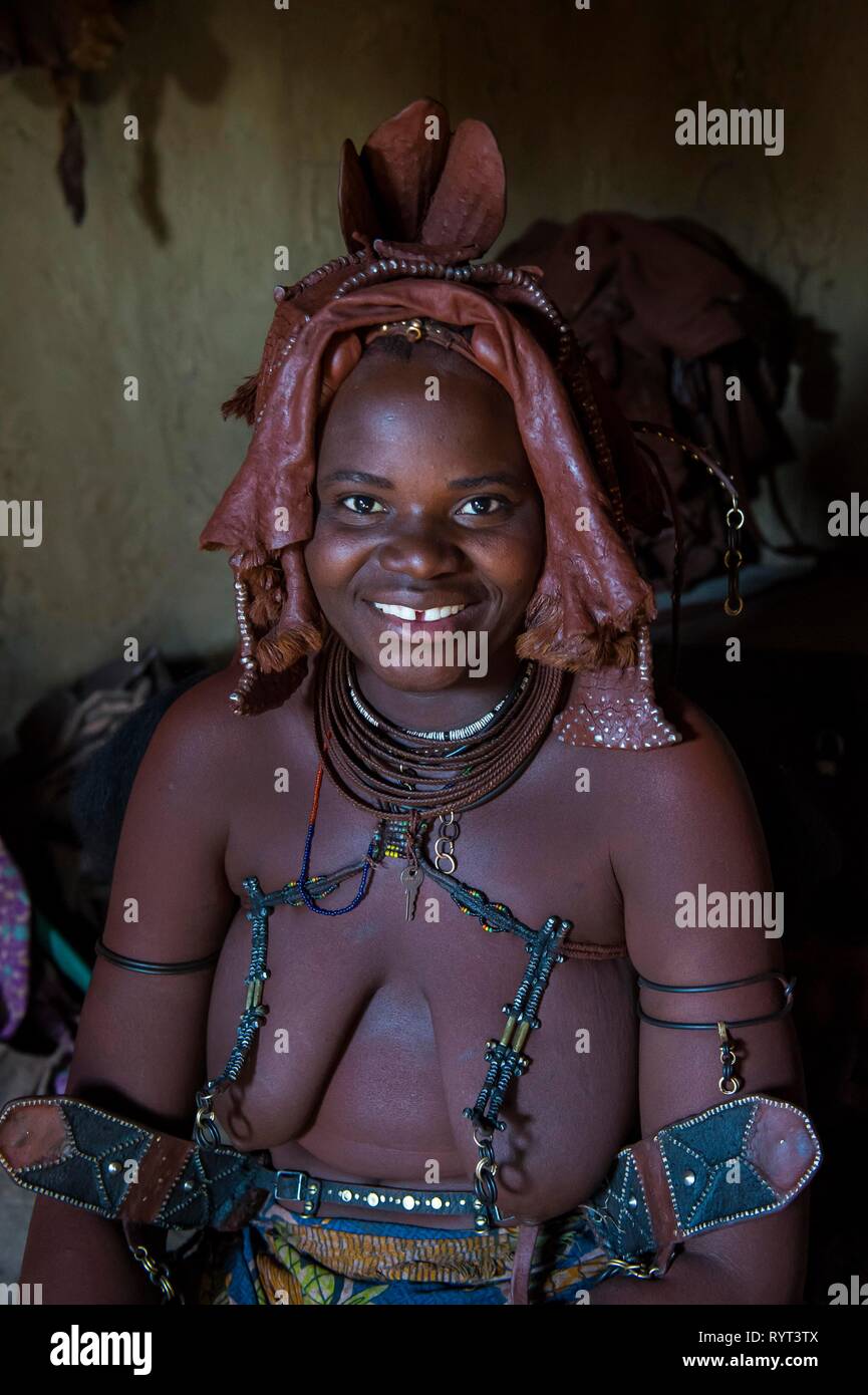 Himba donna seduta nel suo rifugio, Kaokoland, Namibia Foto Stock