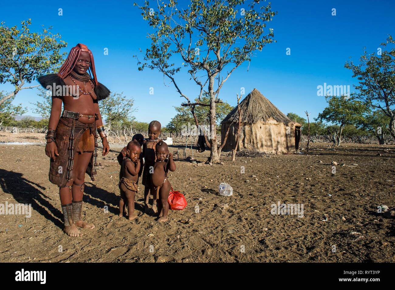 Himba donna con i suoi figli nel villaggio, Sesriem, Kaokoland, Namibia Foto Stock