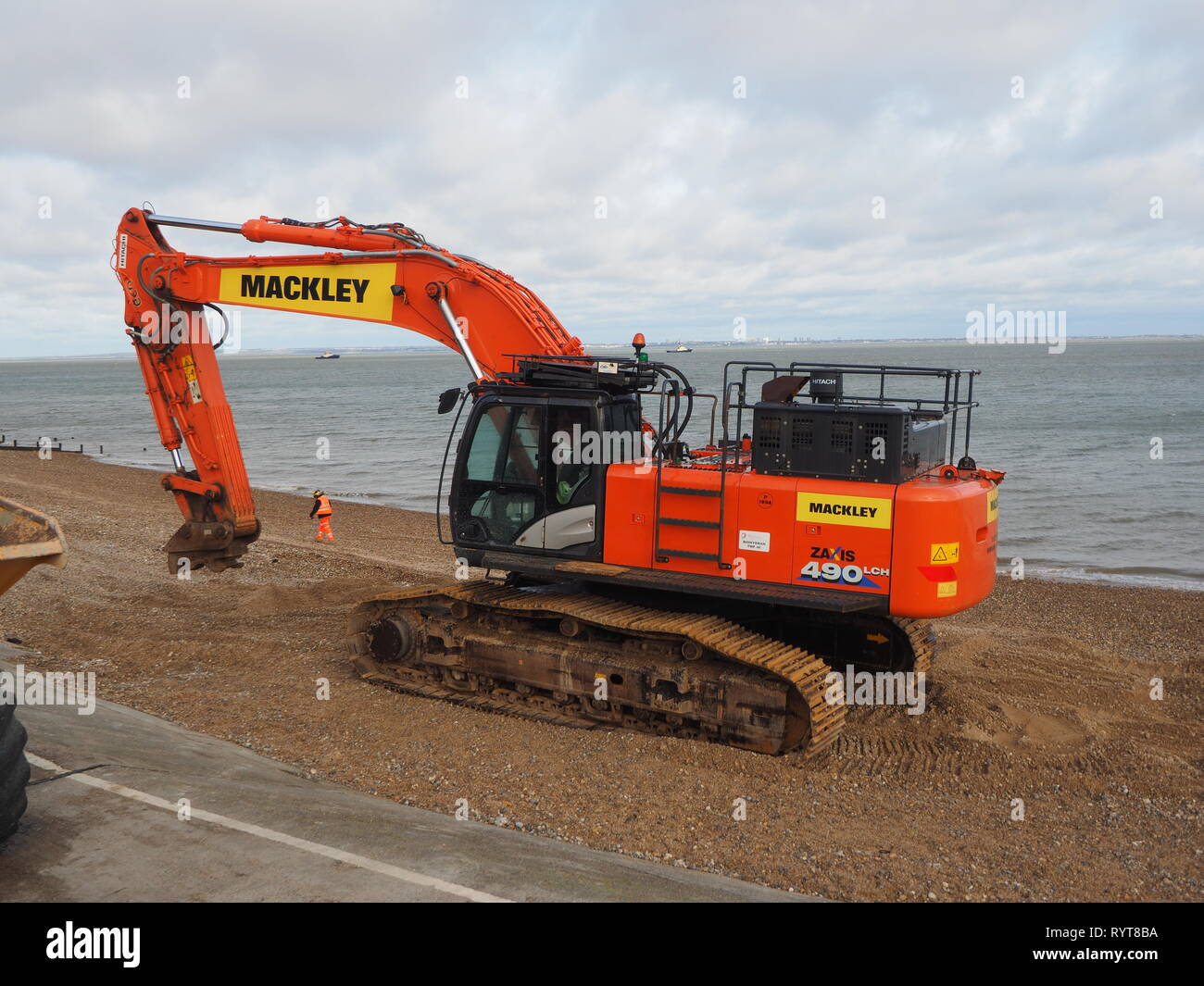 Sheerness, Kent, Regno Unito. Il 15 marzo, 2019. Regno Unito Meteo: un mattino ventoso in Sheerness, Kent con crescente copertura nuvolosa. L'escavatore lavorando sulle difese del mare che è stato sommerso dalla marea di ieri dopo la rottura verso il basso e recuperato a terra superiore alle 1 del mattino questa mattina. Credito: James Bell/Alamy Live News Foto Stock