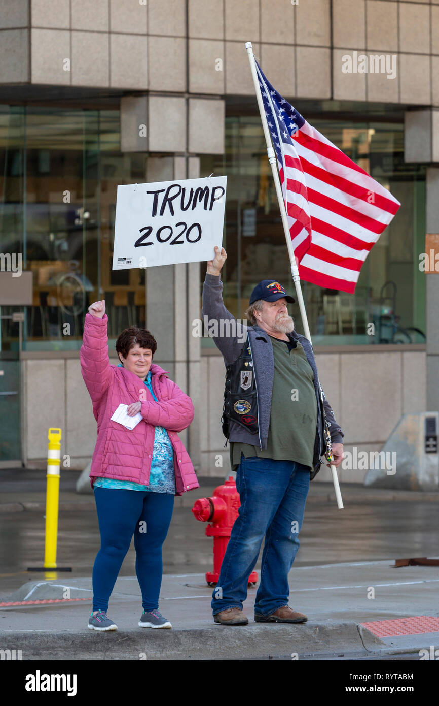 Detroit, Michigan STATI UNITI D'America - 14 Marzo 2019 - Terri Weston (sinistra) e di un uomo che ha detto il suo nome era Pocket, tenuto una bandiera e un Trump 2020 segno al di fuori di un incontro pubblico per promuovere la costruzione di un muro lungo la frontiera messicana. "Costruiamo la parete' evento promosso un'organizzazione dello stesso nome che si sta tentando di sollevare i singoli contributi per finanziare la costruzione di parete. Credito: Jim West/Alamy Live News Foto Stock