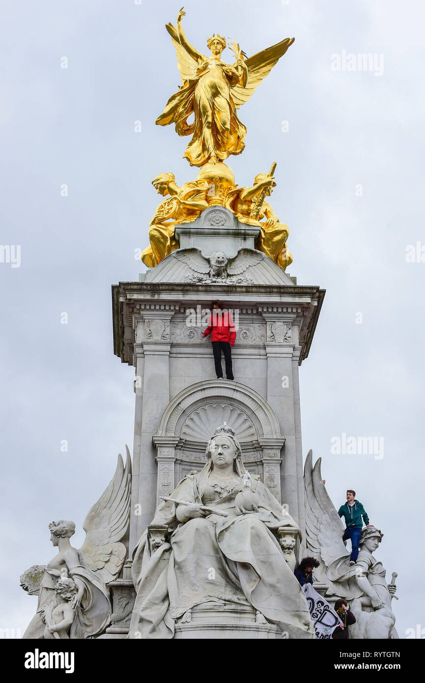 Londra, Regno Unito. Il 15 marzo 2019. Gli studenti salire statue vicino al Queen Victoria Memorial fuori Buckingham Palace. Migliaia di studenti di prendere parte ad un cambiamento climatico sciopero in piazza del Parlamento, marciando verso il basso Whitehall a Buckingham Palace. Simili scioperi da studenti prendono parte in tutto il mondo che chiedono che i governi stanno prendendo provvedimenti contro gli effetti del cambiamento climatico. Credito: Stephen Chung / Alamy Live News Foto Stock