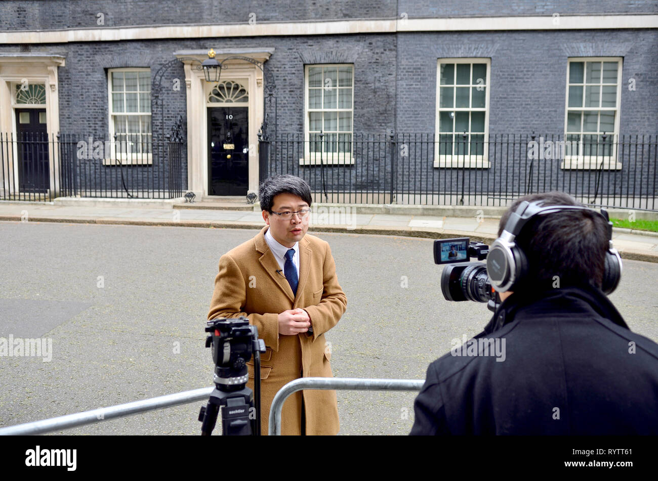 Londra, Inghilterra, Regno Unito. TV giapponese presenter facendo un pezzo alla fotocamera nella parte anteriore del 10 Downing Street Foto Stock