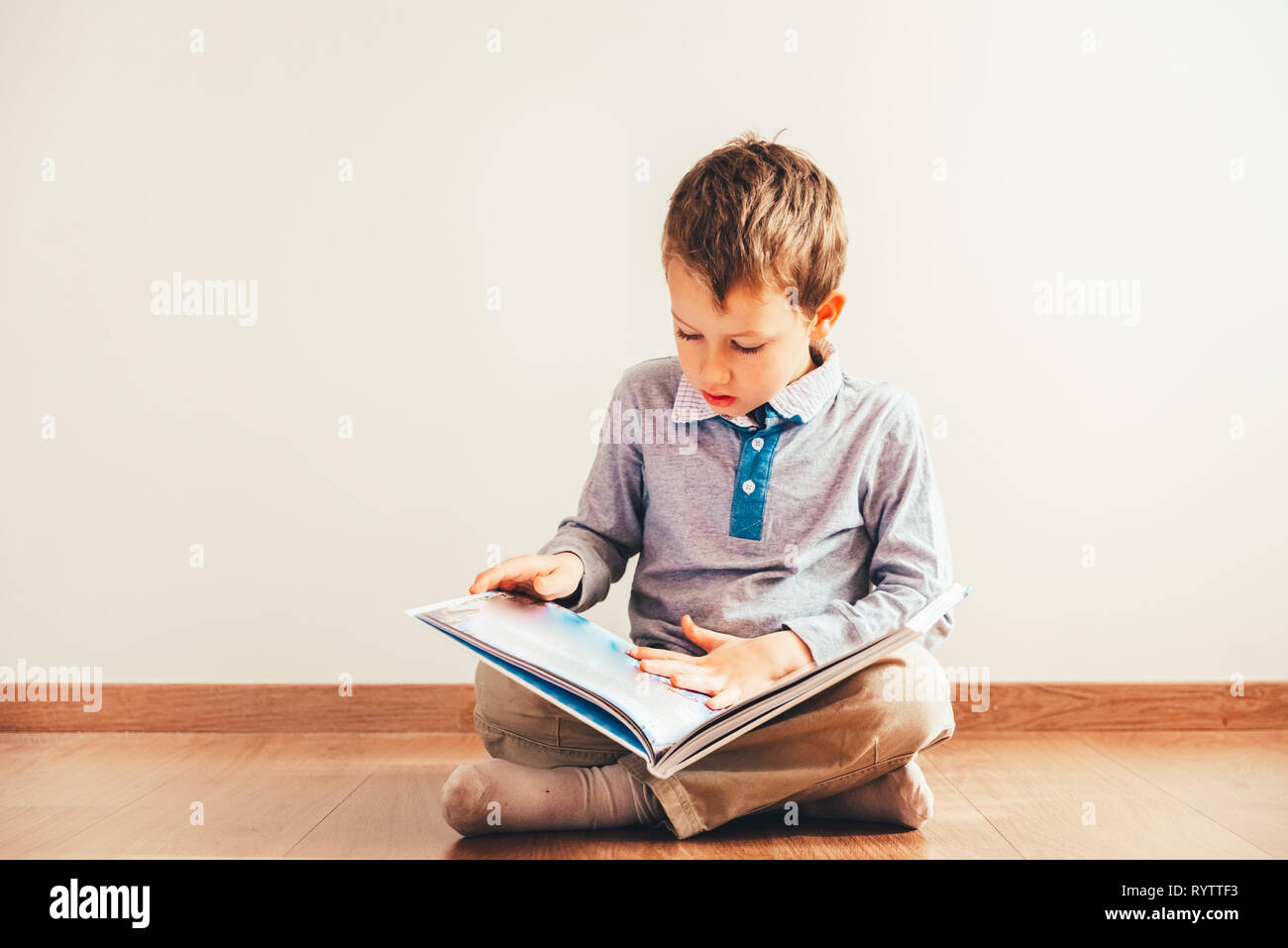 Ritratto di ragazzo interessato a leggere un libro. Foto Stock