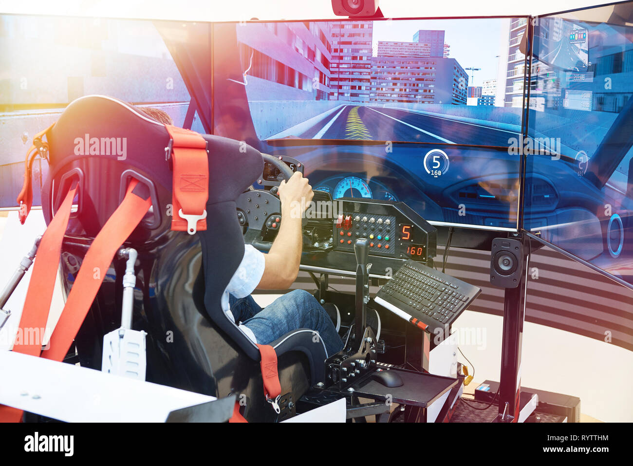 L'uomo gioca su un computer simulatore di corse Foto Stock