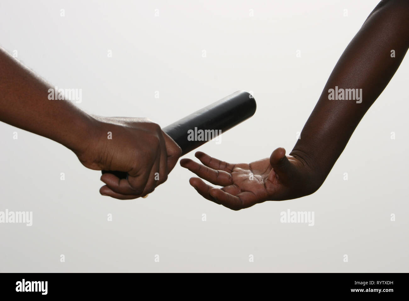 Close-up di mani lo scambio di un relè baton (anche a significare il lavoro di squadra). Foto Stock