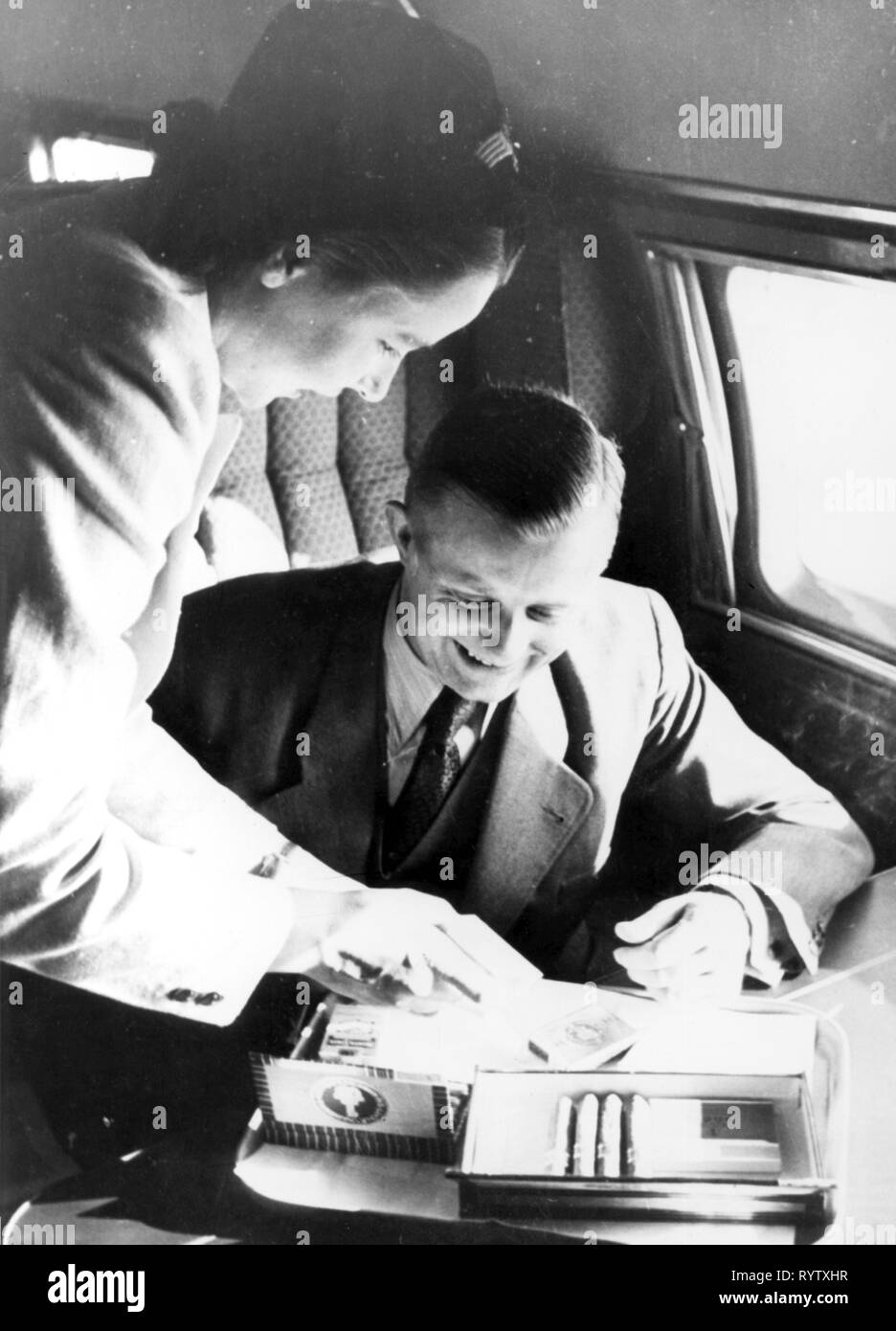 Trasporti / trasporto, aviazione, personale, personale di volo, equipaggio di cabina, una hostess sta offrendo un passeggero una scelta di sigari, a bordo di un Junkers Ju 90 della tedesca Lufthansa, più tardi 1930s, Additional-Rights-Clearance-Info-Not-Available Foto Stock