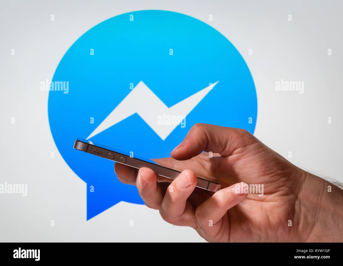 Un uomo utilizzando Facebook Messenger app sul suo telefono cellulare Foto Stock