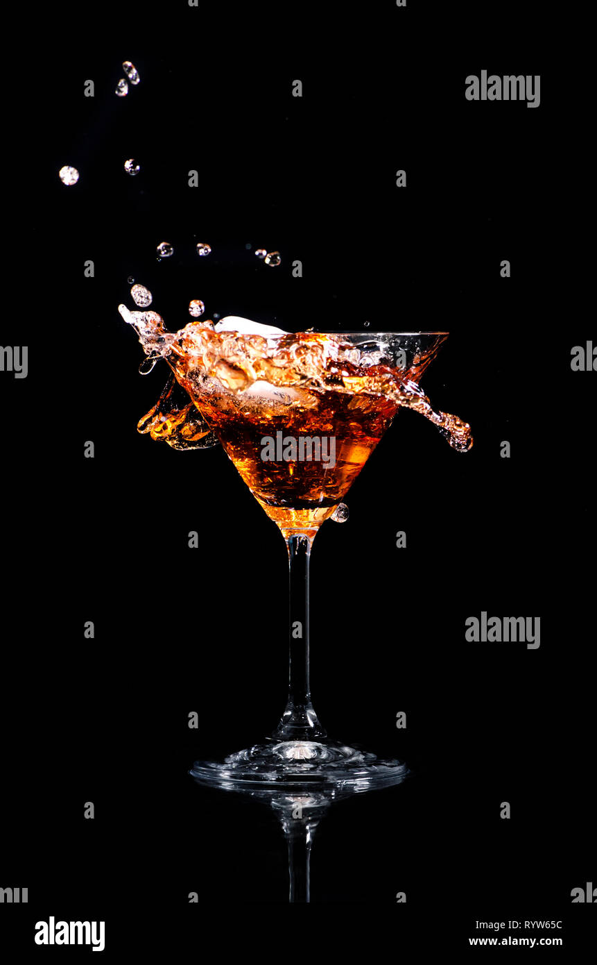 Martini cocktail splash su sfondo nero. Cocktail happy hour e night club il concetto di partito. Foto Stock
