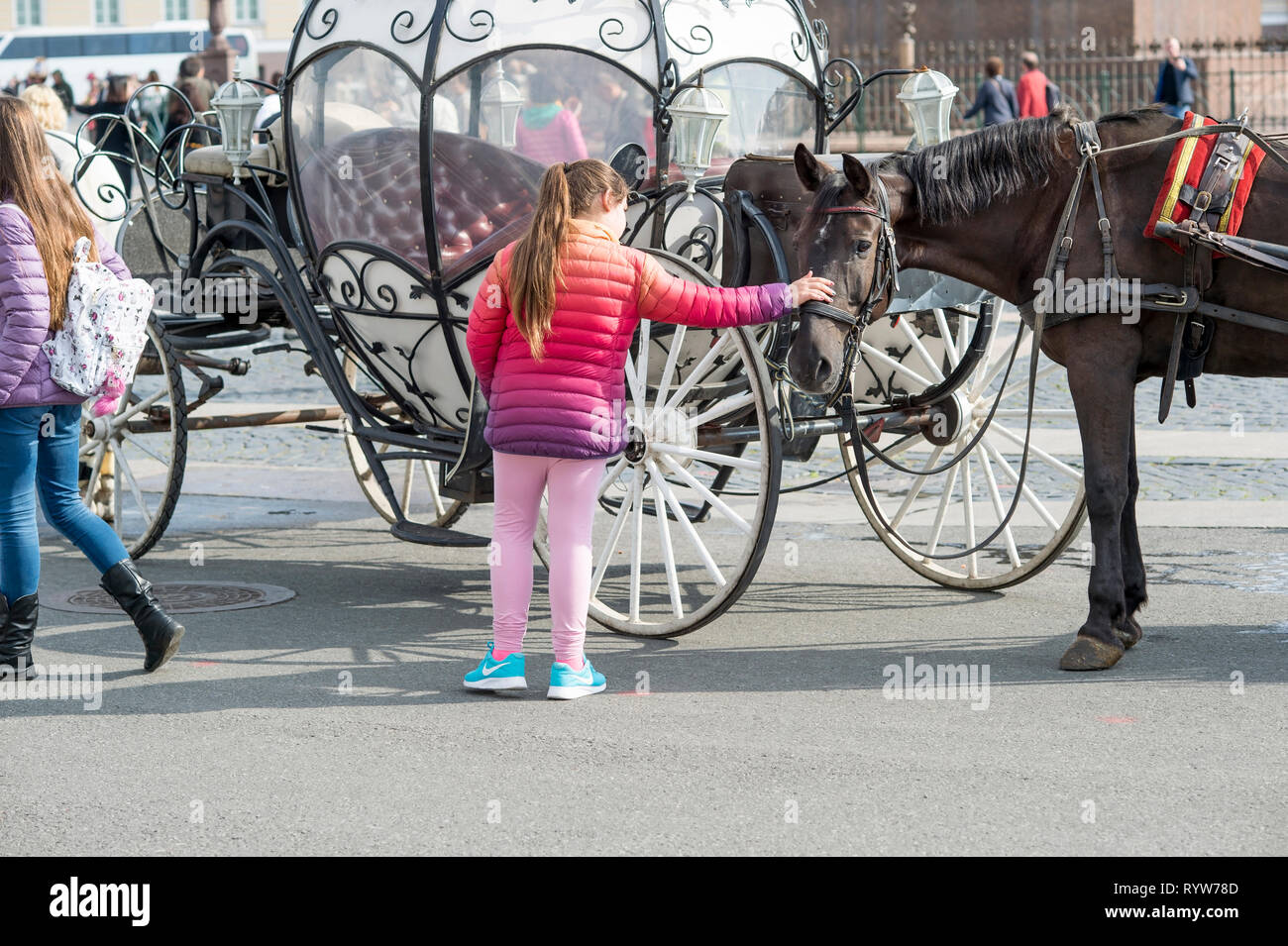 Una ragazza in abiti luminosi a inizio autunno corse a cavallo sulla piazza del Palazzo di San Pietroburgo, Russia, Settembre 2018 Foto Stock