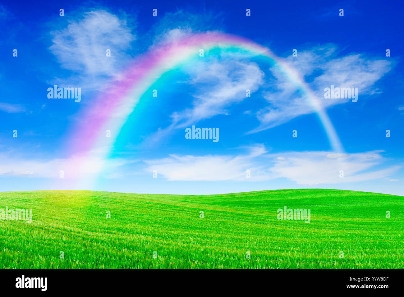 Paesaggio idilliaco, rainbow su dolci prati verdi e sullo sfondo il cielo blu e nuvole bianche Foto Stock