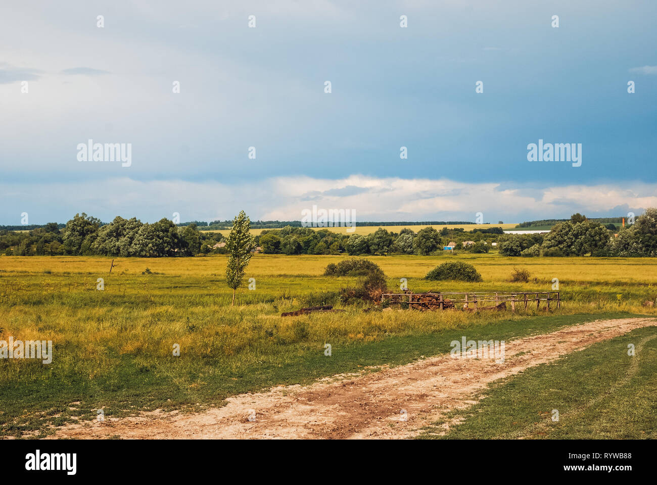 Massa rurale strada retrocedendo nella distanza al paesaggio collinare di Belgorod Regione . Soleggiata giornata di primavera cielo azzurro illuminato dal Foto Stock