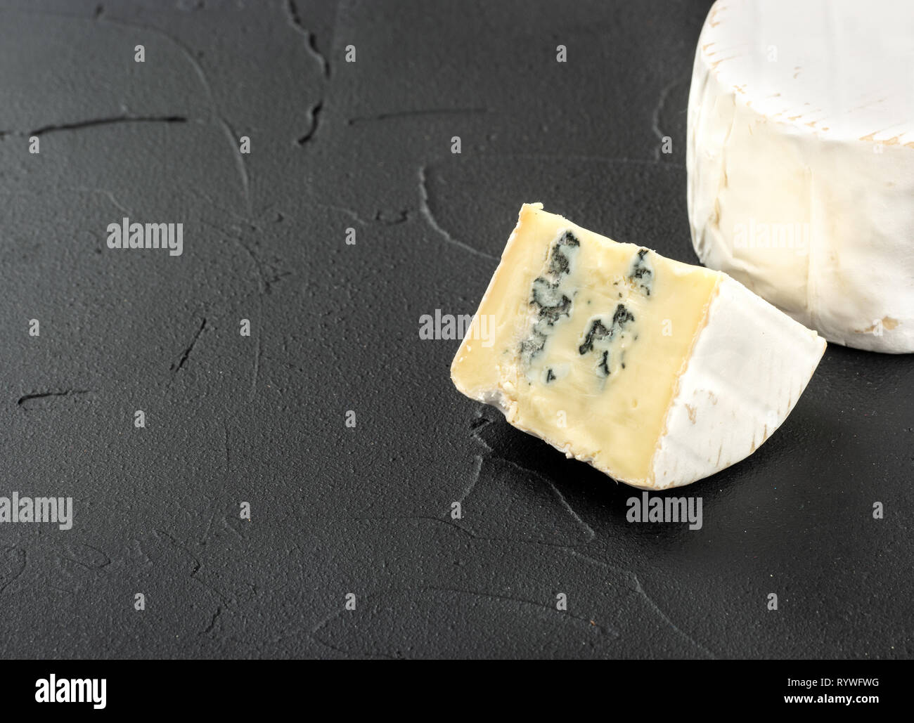 Formaggio Brie con fetta vicino sul scuro dello sfondo in calcestruzzo Foto Stock