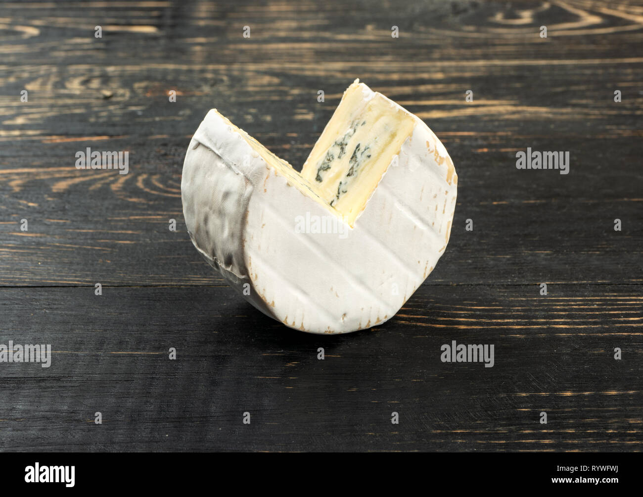 Il pezzo di formaggio brie con stampo su sfondo di legno Foto Stock