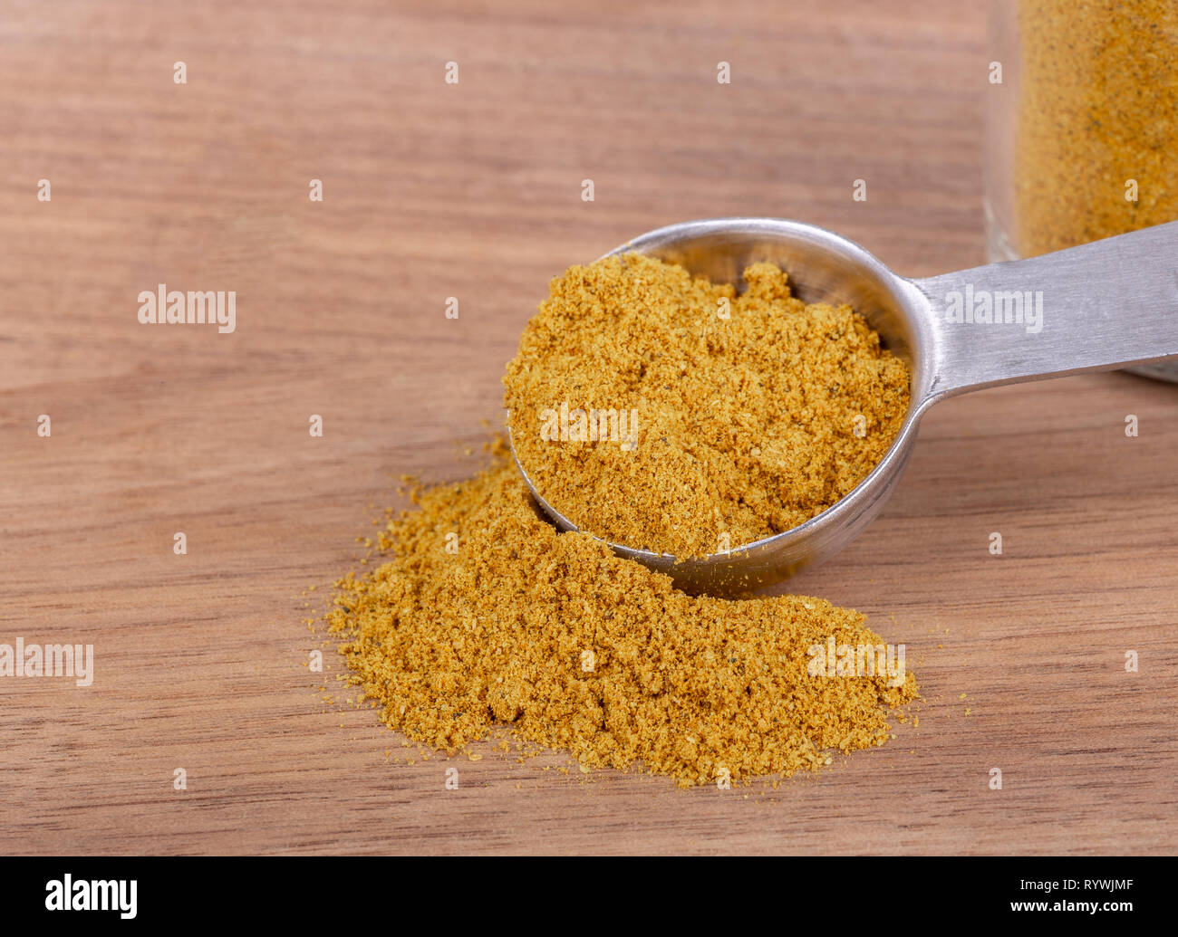 Primo piano della terra curry e misurino su un tavolo di legno con lo spazio di copia Foto Stock