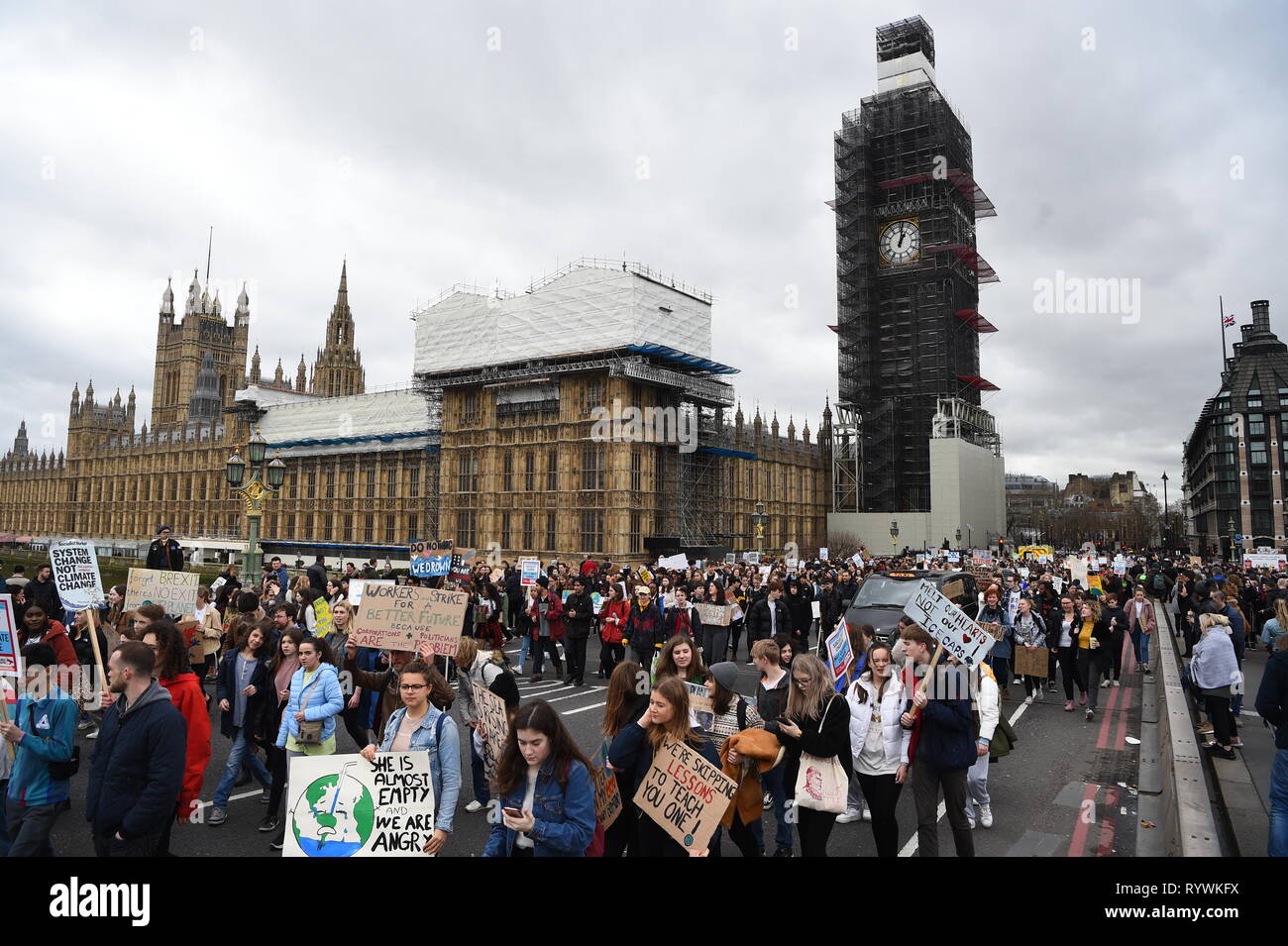Gli studenti marzo passato Case del Parlamento durante la scuola globale sciopero per il cambiamento climatico a Londra, come le proteste sono pianificati in 100 paesi e città nel Regno Unito. Foto Stock