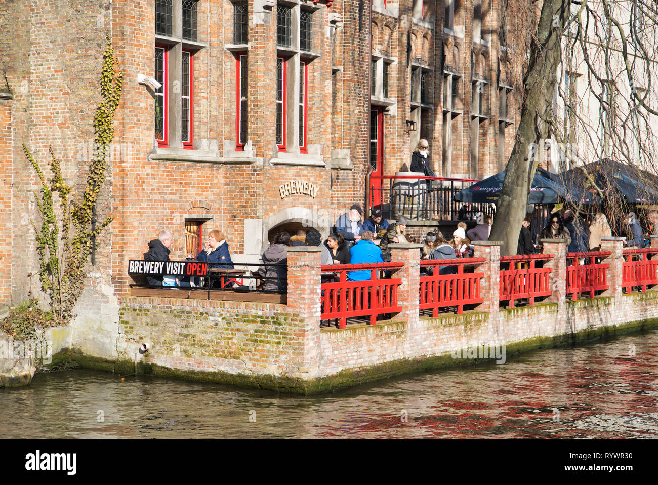 BRUGES, Belgio - 17 febbraio 2019: un ristorante sulle rive di un canale d'acqua. Vista dalla barca per gite Foto Stock