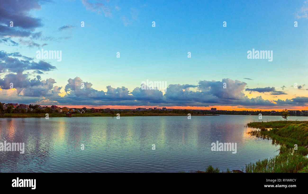 Bel cielo azzurro con cumulus nuvole sopra il fiume, riflessa nell'acqua. Acqua di fiume paesaggio in Kriviy Rih, Dnipropetrovs regione, Ucraina Foto Stock