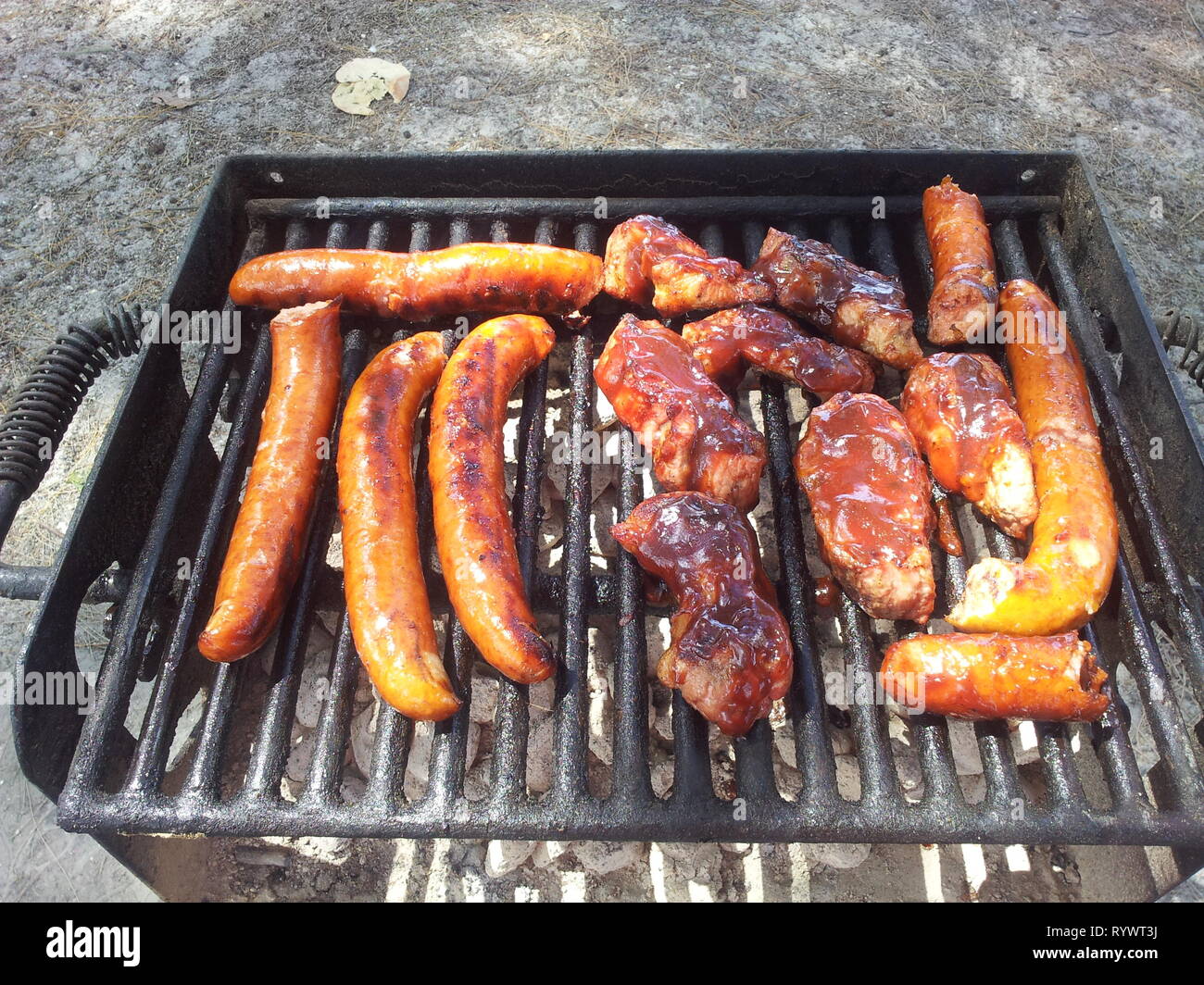 Bar-B-Que la carne sulla griglia in spiaggia con gli amici e la famiglia è l'uso migliore di una vacanza in Florida Foto Stock