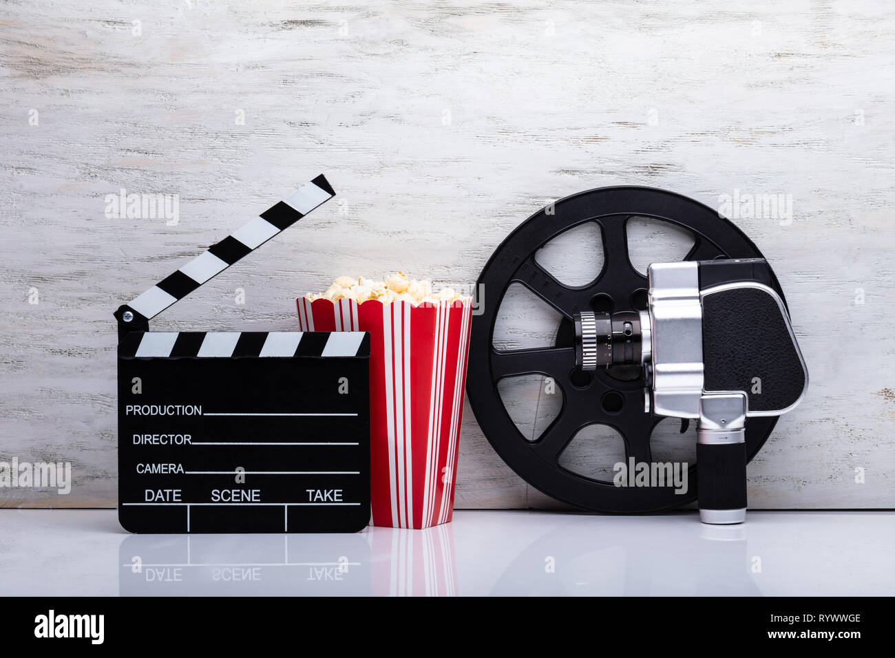 Close-up di un Movie Camera con popcorn e battaglio Scheda contro uno sfondo bianco Foto Stock