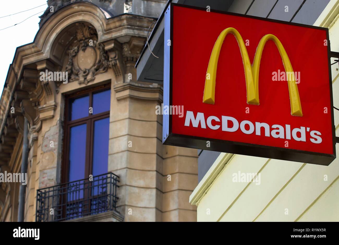 Bucarest, Romania - 10 Ottobre 2018: un logo di McDonald's fast food company è visualizzato sul lato anteriore di un ristorante nei pressi di un vecchio edifici che si trovano Foto Stock