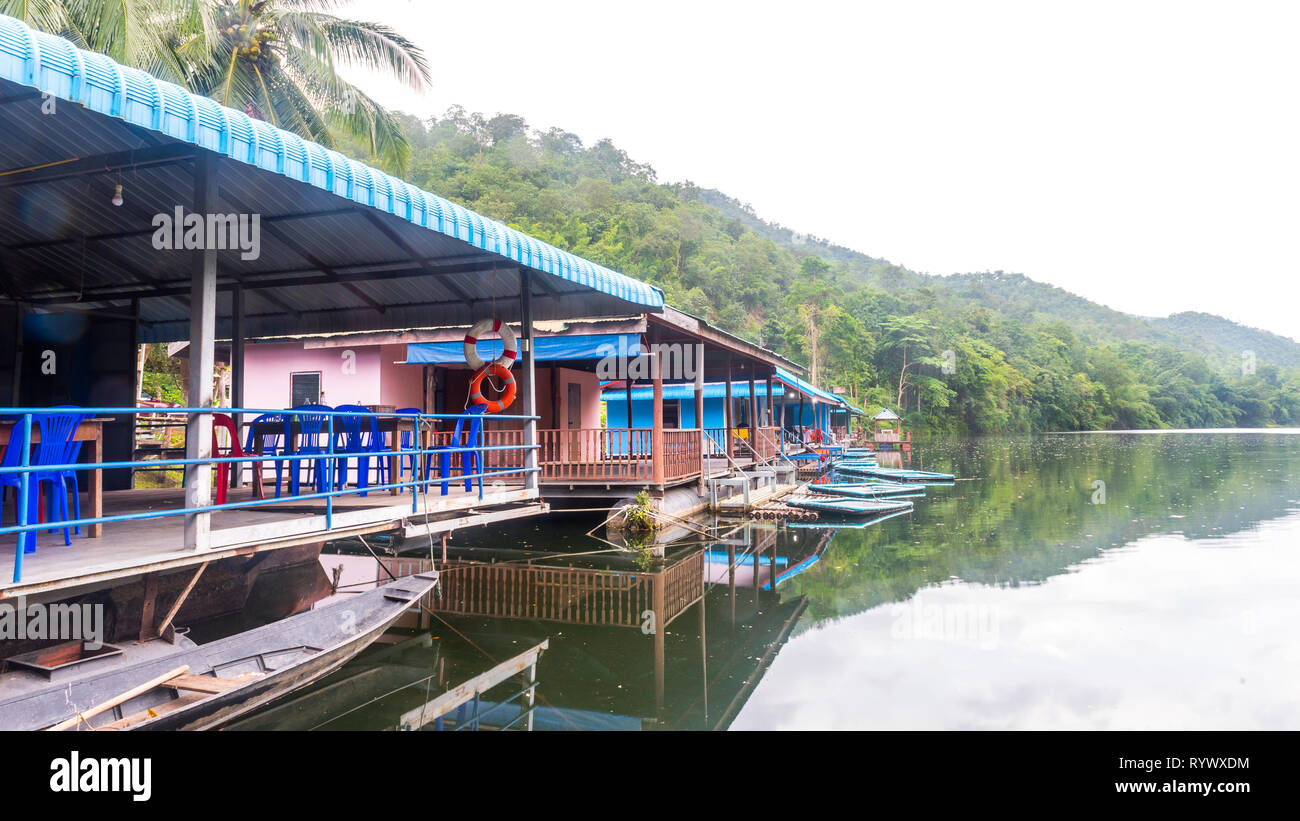 Ristorante e hotel sul fiume con la tradizionale barca in primo piano Foto Stock