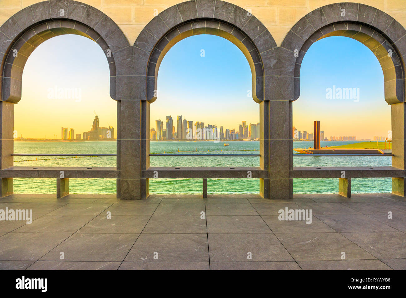 I moderni grattacieli di Doha West Bay skyline al tramonto la luce attraverso gli archi del museo si trova lungo la corniche in Qatar capitale. Doha in Qatar. Medio Foto Stock