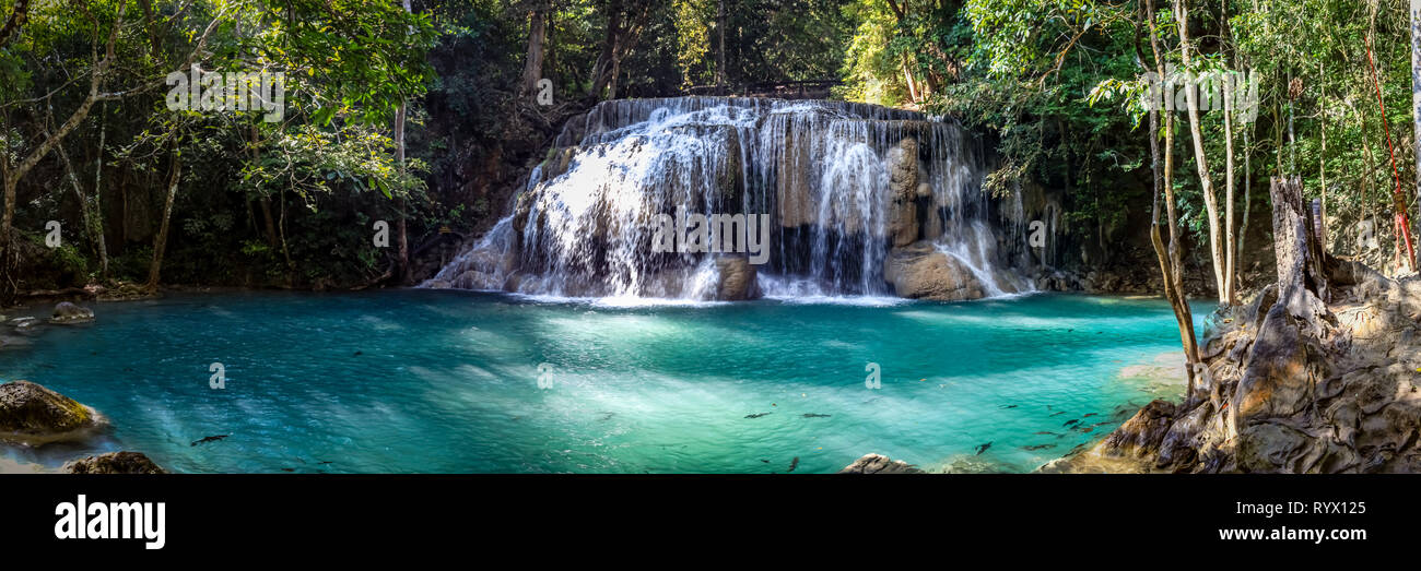 Uno dei più grandi cascate del Parco Nazionale di Erawan in Thailandia con alberi a sinistra ha un aspetto lattiginoso Aqua pool con alcuni pesci Foto Stock