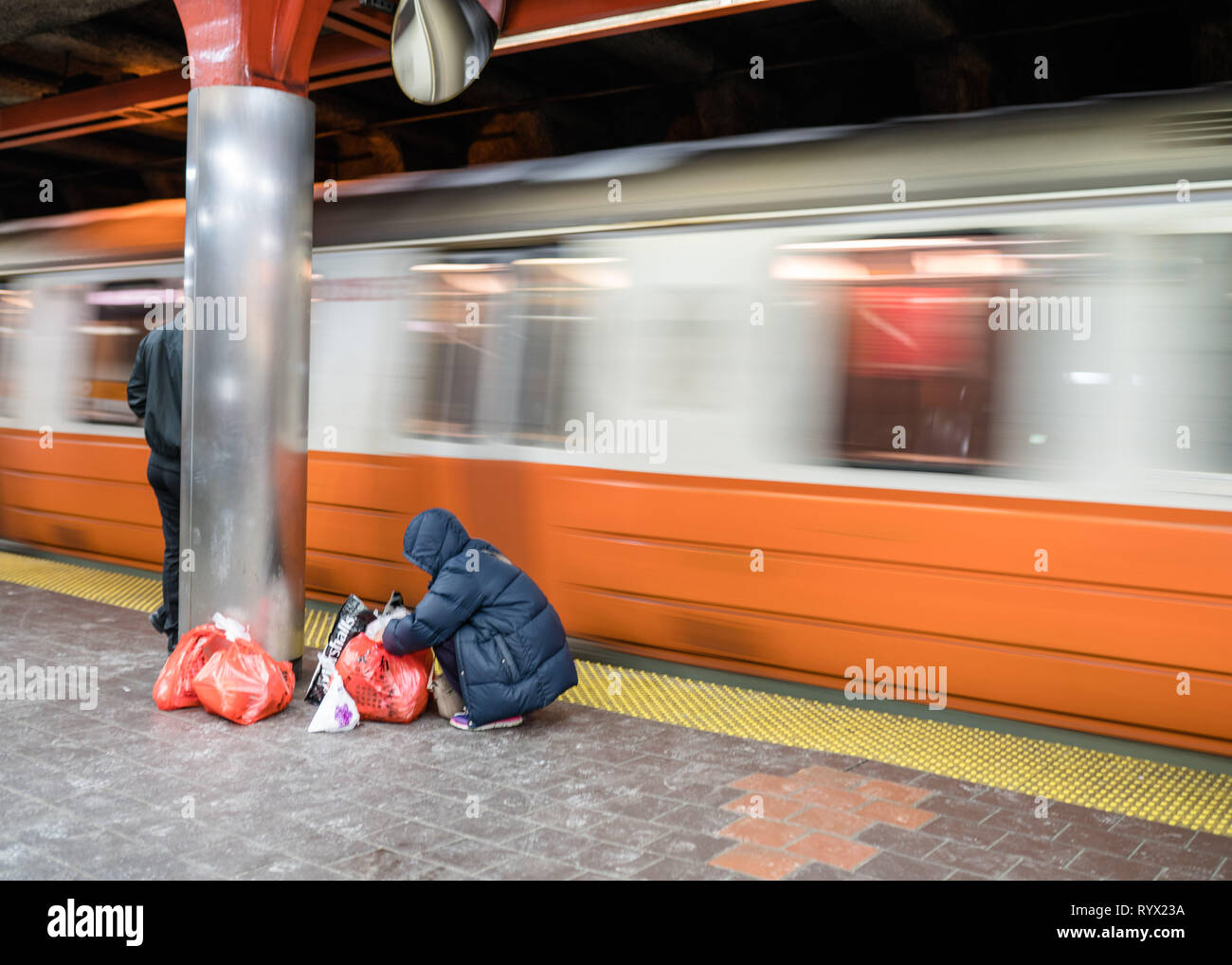 Persona gli elementi di raccolta mentre il treno arriva Foto Stock