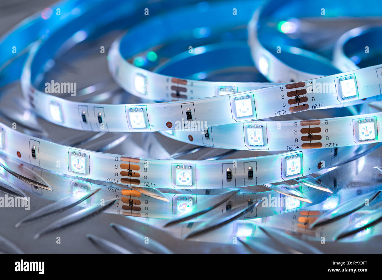 Luminosa LED RGB stripn luce nella parte anteriore del coloratissimo bokeh di fondo in metallo piastra Diamond Electronics risparmio energetico decorazione sfondo tecnologico Foto Stock