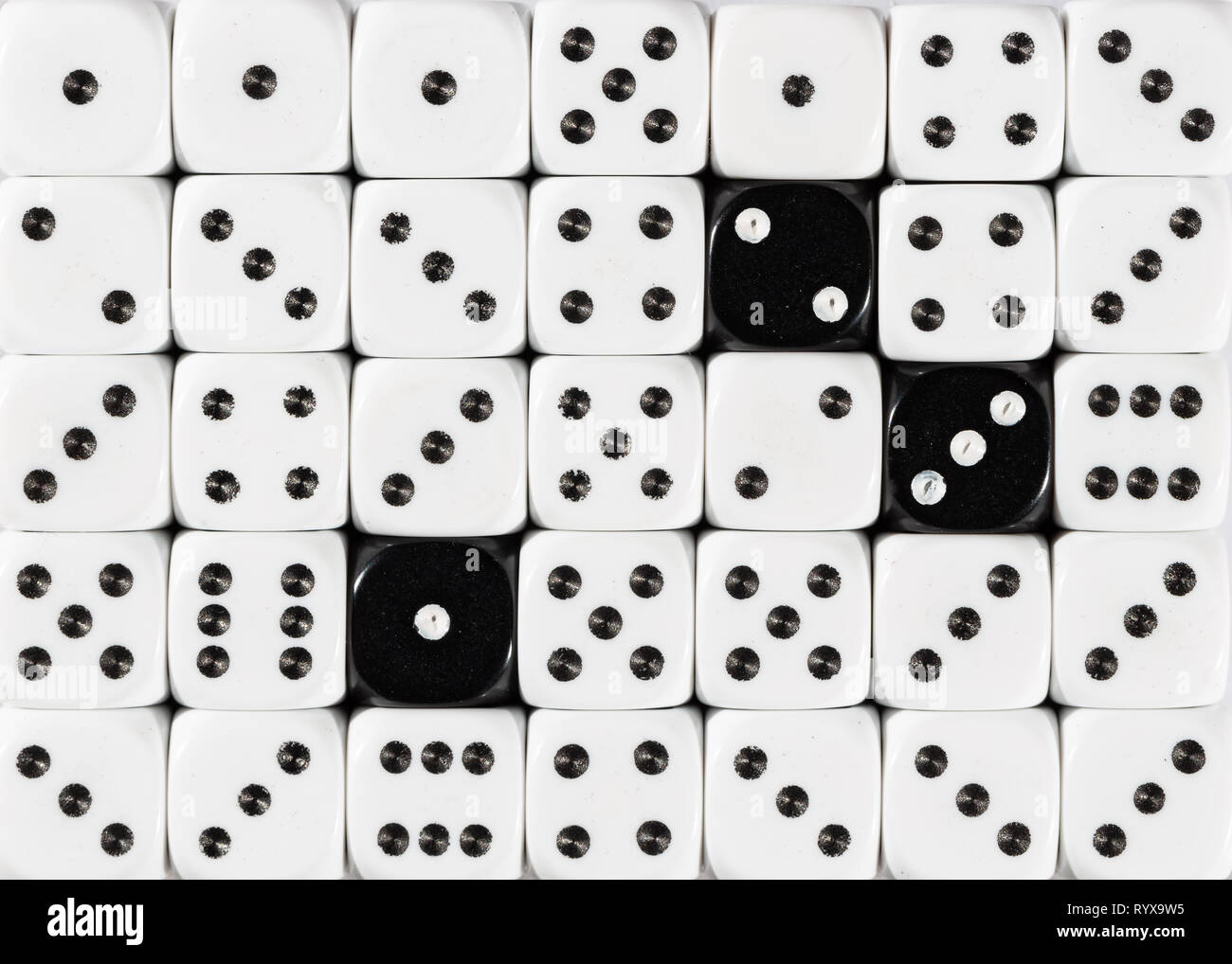 Sullo sfondo di un casuale bianco ordinato plinti con tre cubi nero Foto Stock