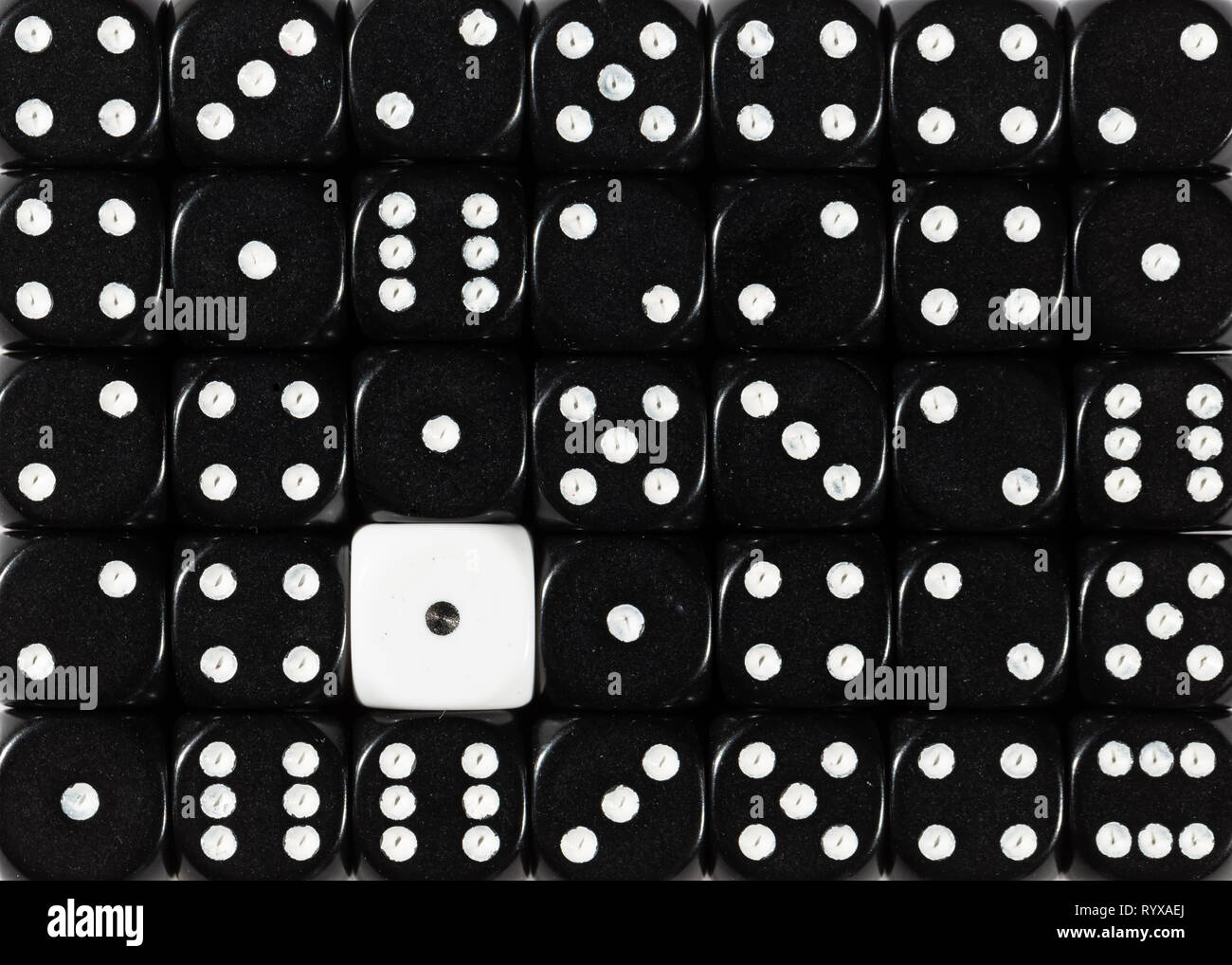 Sullo sfondo di un casuale nero ordinato plinti con un cubo bianco Foto Stock