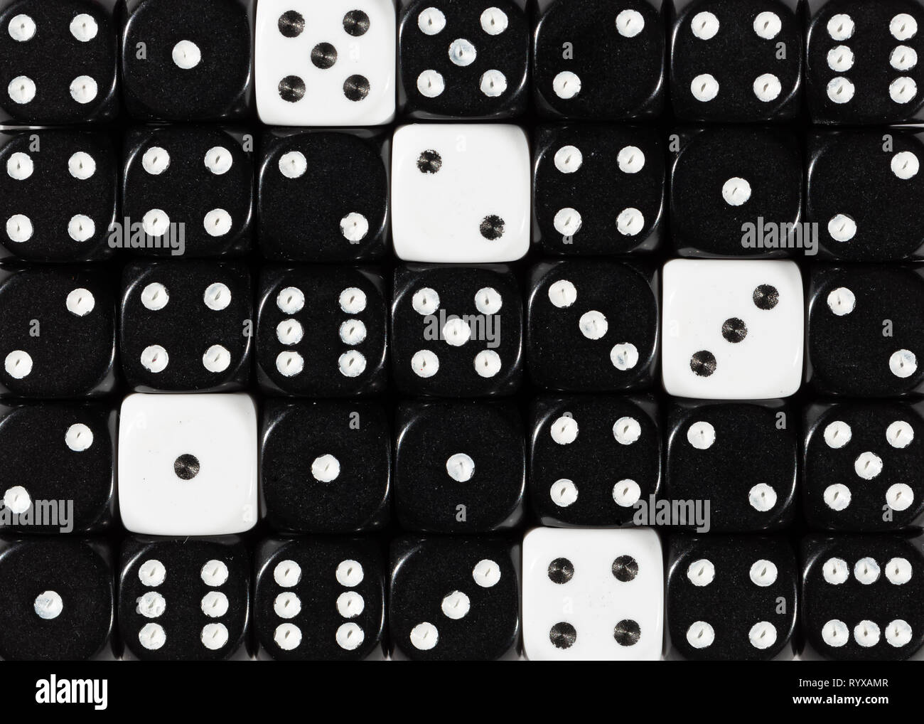 Sullo sfondo di un casuale nero ordinato plinti con cinque cubetti di bianco Foto Stock