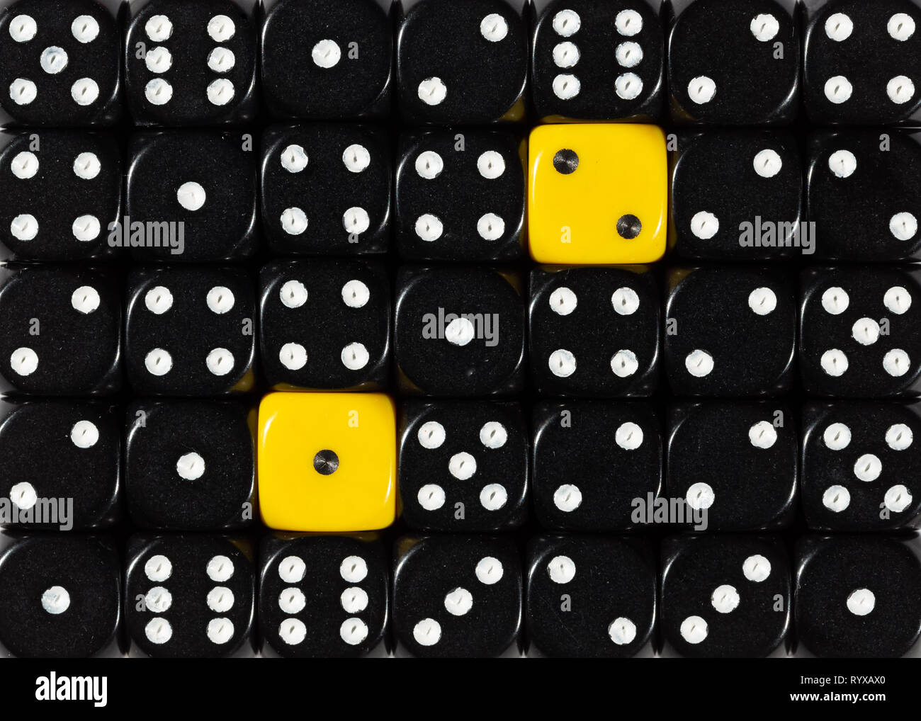 Sullo sfondo di un casuale nero ordinato plinti con due cubi giallo Foto Stock